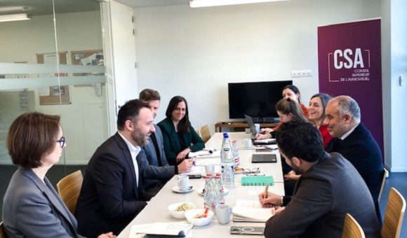 Photo couleur. Un groupe de femmes et d'hommes autour d'une table de réunion, en Belgique à Bruxelles